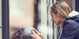 Femme prenant une photo avec un smartphone dans la rue